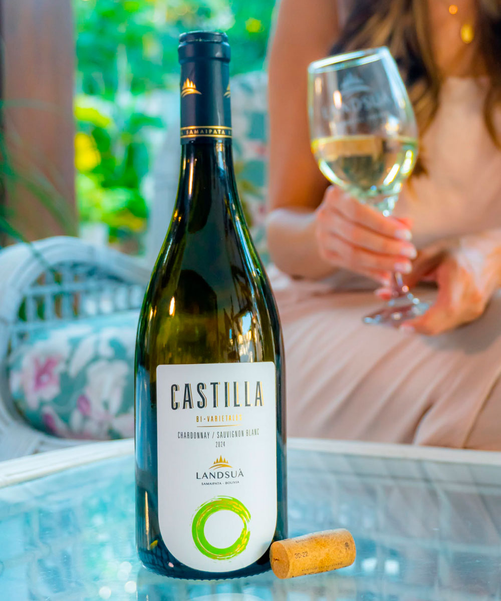 Vino Blanco Castilla Chardonnay Sauvignon Blanc - Bodegas Landsuá Botella de vino blanco bivarietal Castilla Chardonnay Sauvignon Blanc de Bodegas Landsuá junto a una copa y corcho en mesa.